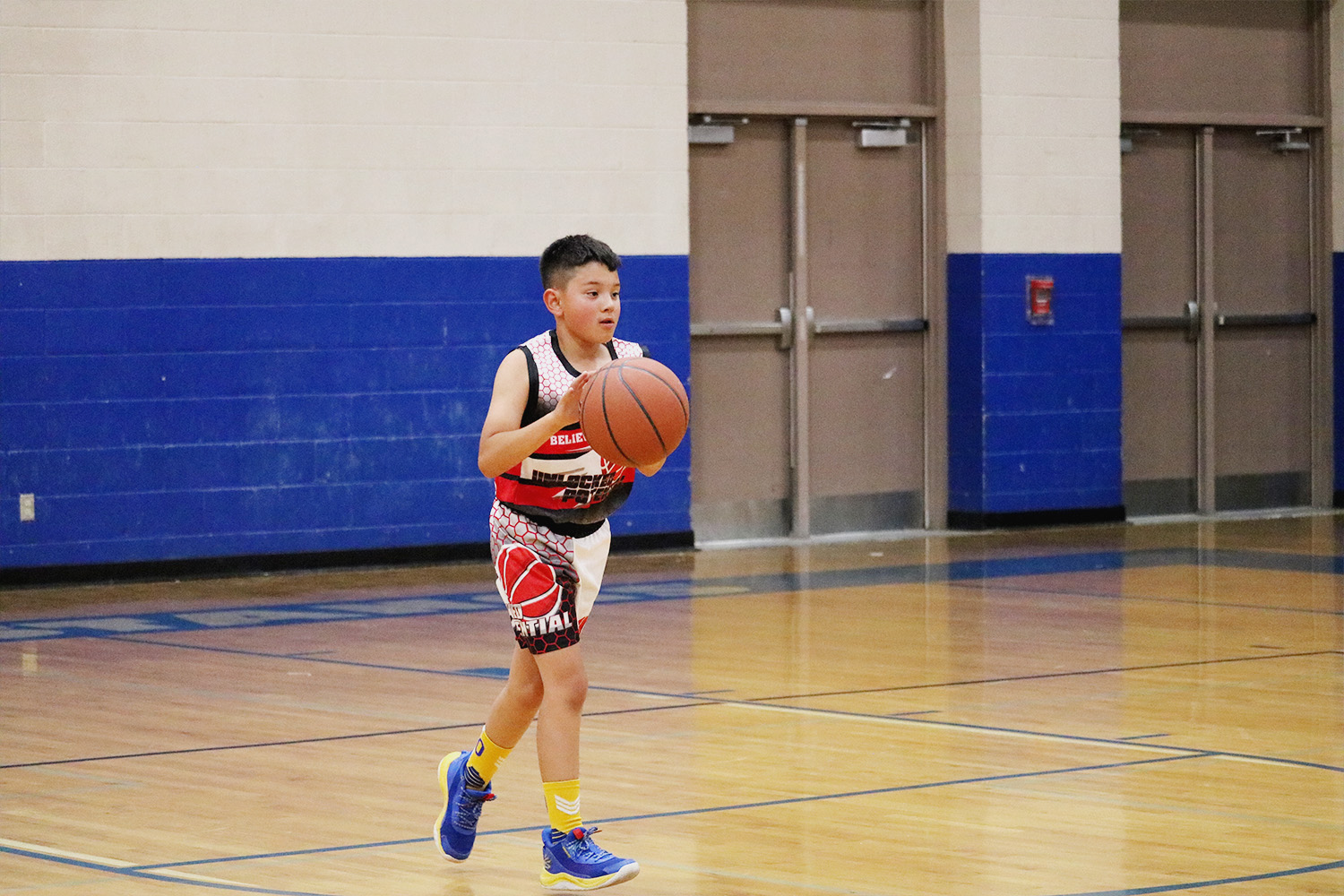 A picture of a player dribbling a basketball in Unlocked Potential's flag elite fall youth basketball league