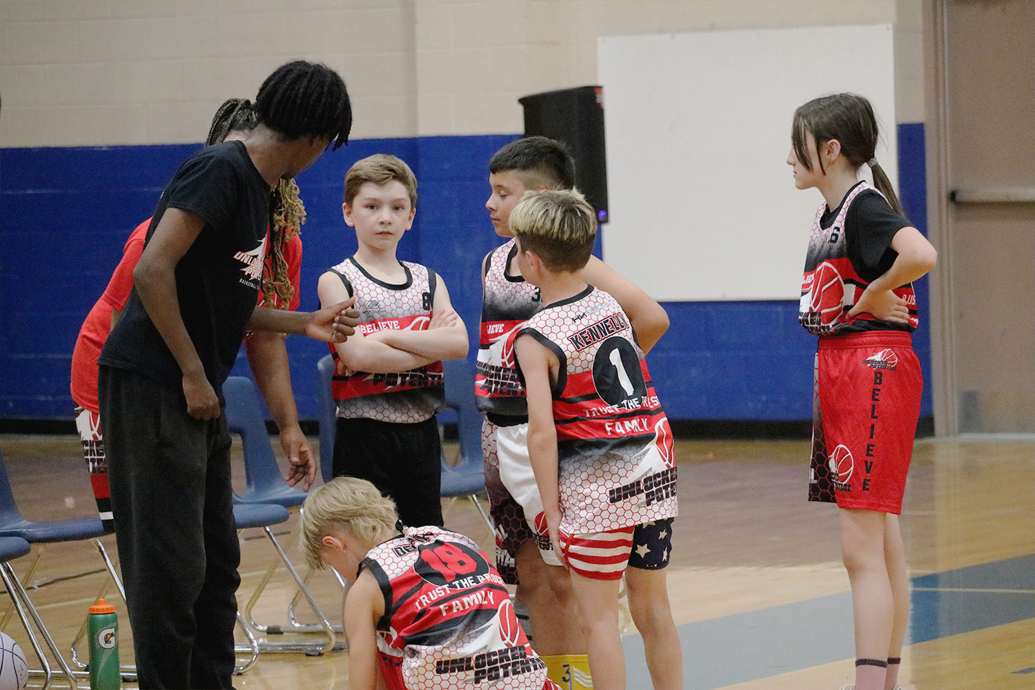 A picture of a coach, coaching a youth basketball team in Unlocked Potential's flag elite fall youth basketball league
