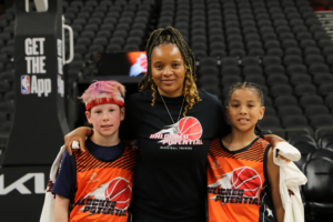 A picture of a youth basketball team playing in the Unlocked Potential Flag Elite youth winter basketball league championship with coach Kiki.