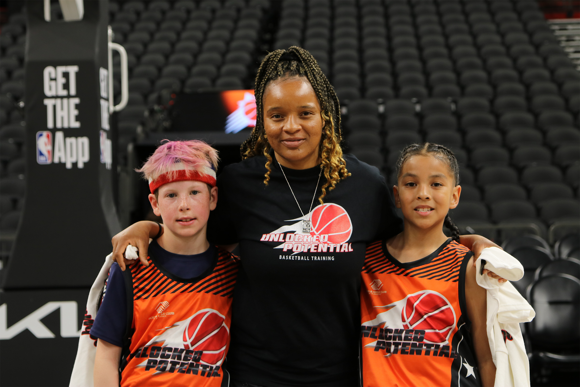 A picture of a youth basketball team playing in the Unlocked Potential Flag Elite youth winter basketball league championship with coach Kiki.