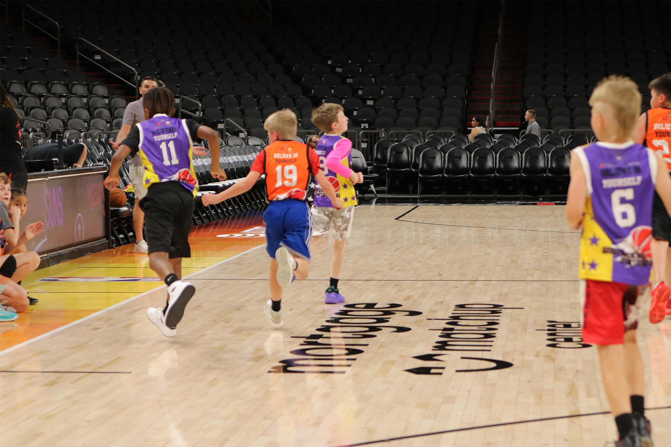 A picture of a youth basketball team playing in the Unlocked Potential Flag Elite youth winter basketball league championship at the mortgage matchup arena.