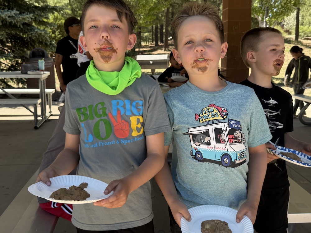 A picture of two kids eating melted bars of chocolate at the Unlocked Potential back to school fun bash camp in Flagstaff, AZ