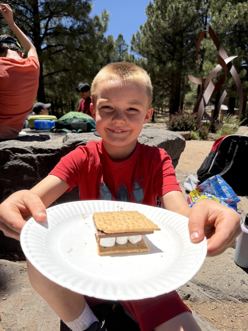 A picture of a child eating a s'more at the Unlocked Potential back to school fun bash camp in Flagstaff, AZ