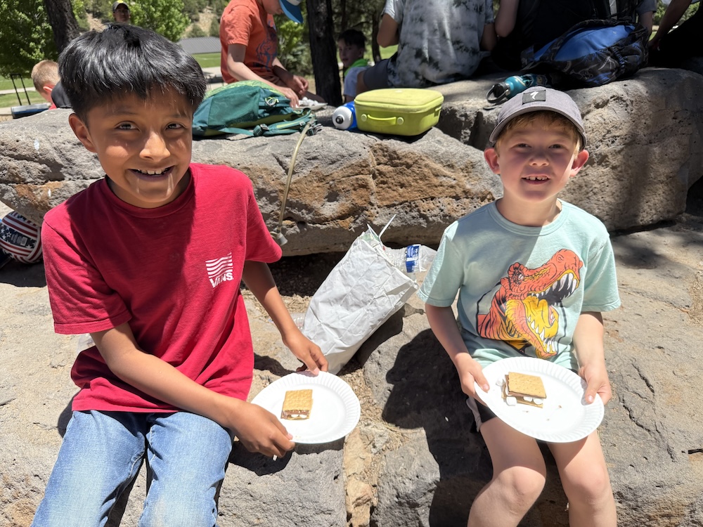 A picture of two kids eating s'mores at the Unlocked Potential back to school fun bash camp in Flagstaff, AZ